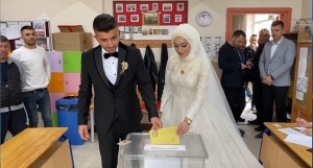 Oy kullanmaya gelin ve damatlıkla geldiler