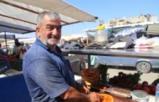 Depremde işletmesi yıkılan Hasan usta, öcce dürümü müşterilerine tezgahta sunuyor