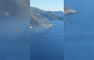 Fethiye'de bir koyda teknede çıkan yangına müdahale ediliyor