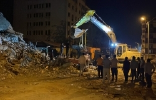 Hatay'da ağır hasarlı bina yıkım sırasında iş makinesinin üzerine devrildi