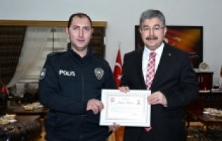 Engelli vatandaşa şemsiye tutarak ıslanmasını önleyen polise başarı belgesi