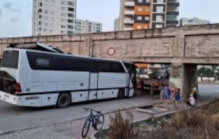 Mersin'de köprü altında sıkışan otobüs, vinç yardımıyla çıkartıldı